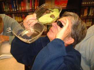 Teacher using a jeweler's loupe at a Private Eye Workshop